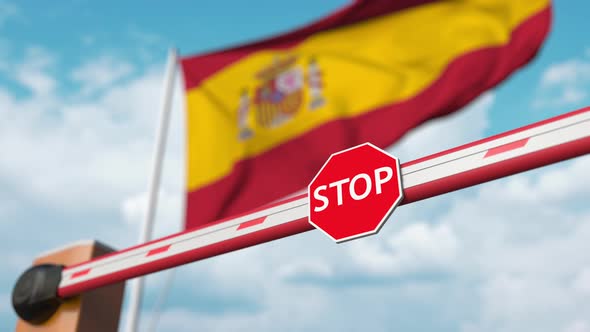 Barrier Gate Being Opened with Flag of Spain As a Background