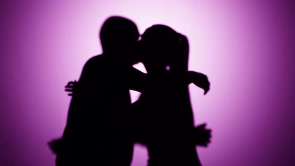 Shadows of Man Hugging Woman on Pink Background