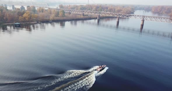 Flight of a Drone Over a Boat on the River in Autumn Covered with Fog, Against the Background of the