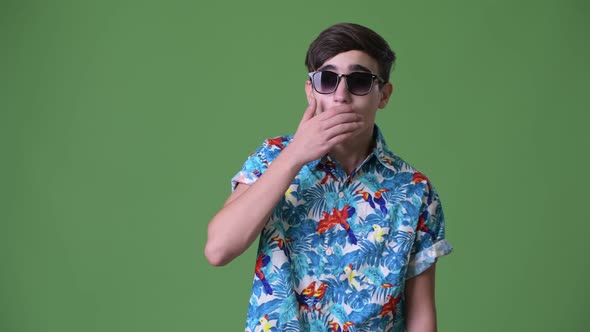 Young Handsome Iranian Teenage Boy Ready for Vacation Against Green Background