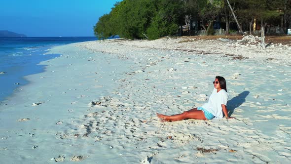 Beautiful ladies enjoying life on marine bay beach voyage by shallow ocean and white sandy backgroun