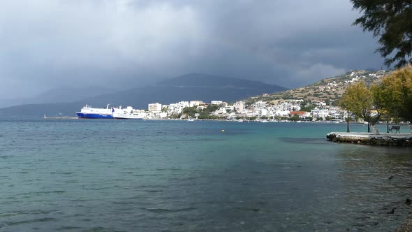 Dark clouds above the ferry and the village Marmari