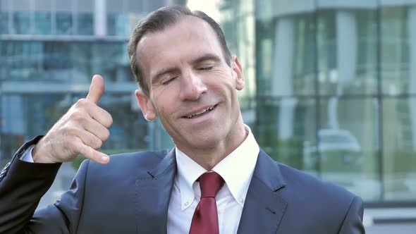 Call Me for Help Gesture By Middle Aged Businessman