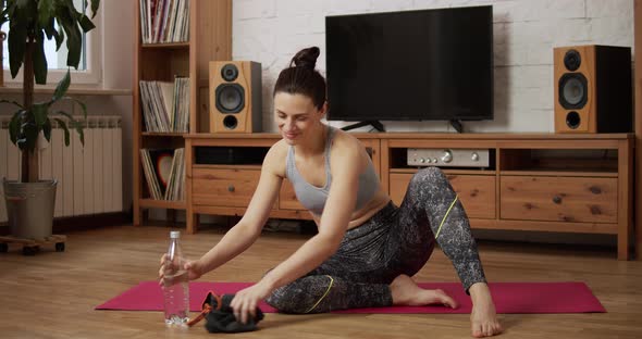 Young Woman Is Resting and Drinking Water After Exercising at Home