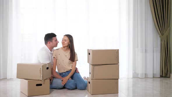 Son Pops Up From Behind Boxes Near Parents Sitting on Floor