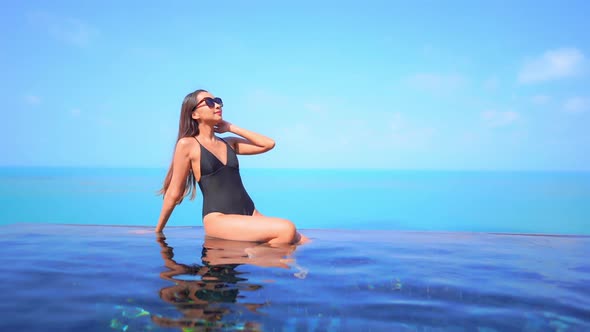 Young asian woman enjoy around outdoor swimming pool for leisure