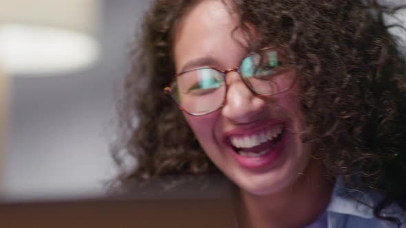 Attractive Happy Young Girl Student Studying at the College Library Sitting at the Desk Using Laptop