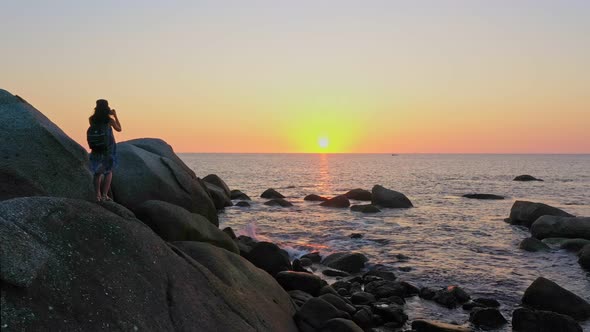 Aerial View A Lady Standing Watching Sunset On The Large Rock.