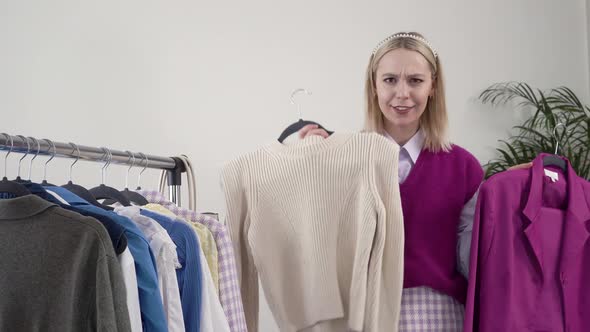 A Female Stylist Shows Handmade Clothes Smiles and Looks at the Camera