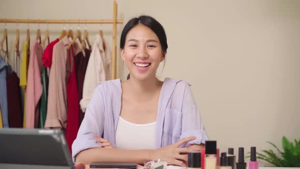 Beauty blogger present beauty cosmetics sitting in front laptop for recording video Asian woman.