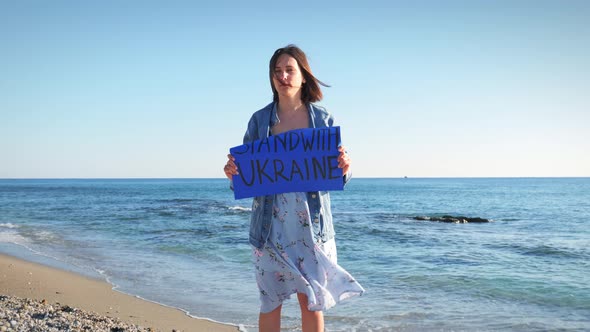 Woman holding banner Stand With Ukraine
