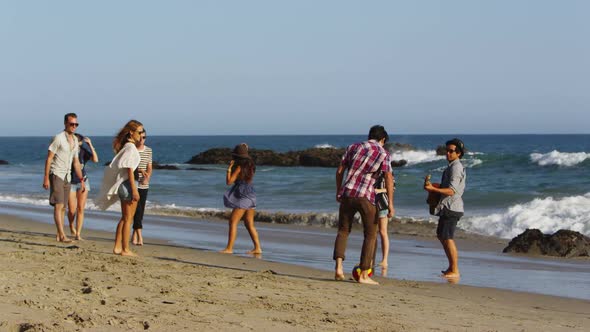 Group of young people walking together along beach