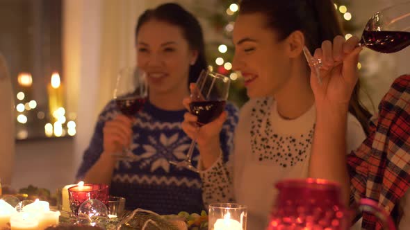 Happy Friends Drinking Red Wine at Christmas