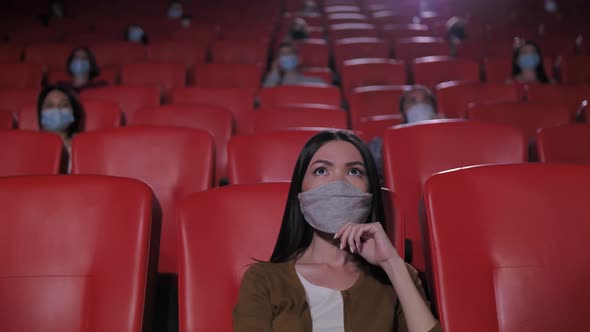 Portrait of Asian Woman in Mask in Movie Theater