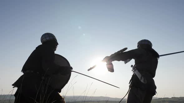 Silhouettes of Warriors Viking Are Fighting with Swords and Shields