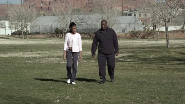 Couple walking through the park as man gets chest pains.