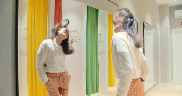 Happy Attractive Woman Dancing in Fitting Room of the Store During Shopping Time