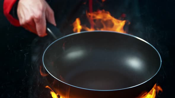 Super Slow Motion Shot of Chef Holding Empty Frying Pan and Flames at 1000Fps