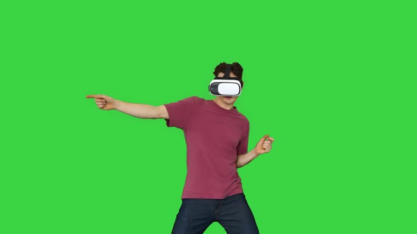 Advanced Gamer in Casual Outfit Playing Dancing Game in VG Headset on a Green Screen, Chroma Key