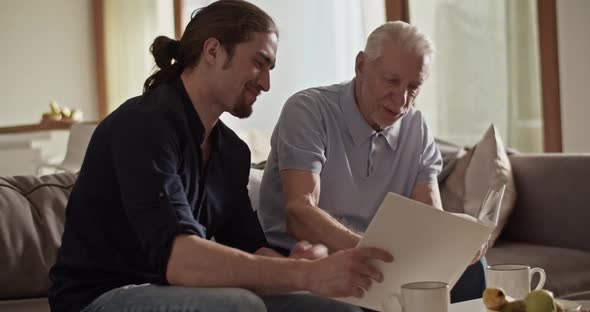 Father and Son Examining Photos Together