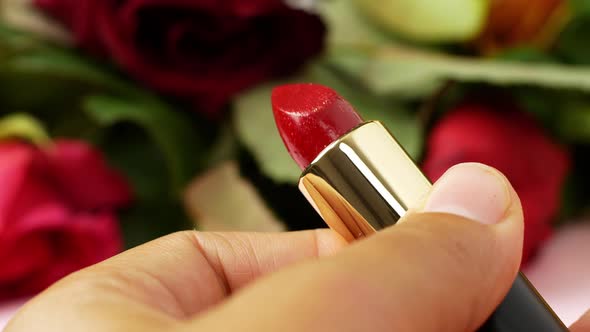 Close-up woman opens red lipstick before makeup. Facial care, makeup application, lipstick.