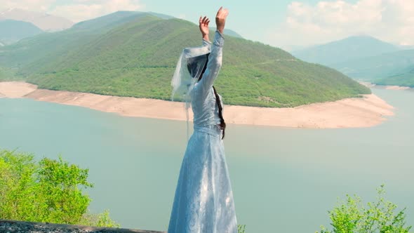 A Girl in a Georgian National White Dress is Dancing