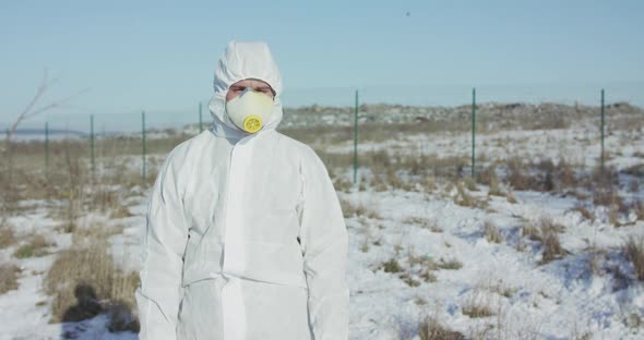 Man in Full Cover Suit Shows Stop with Hands on Abandoned Nature in Winter