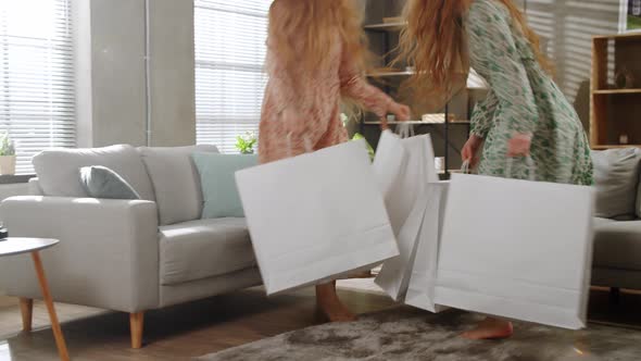 Two Young Sisters Twins are Returned Home From the Store with Large White Shopping Bags