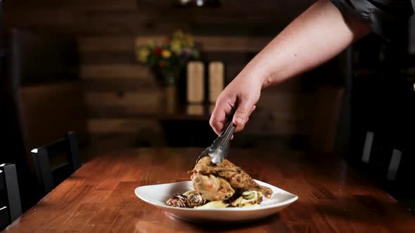 Chef Plating Roasted Chicken On Wooden Table. wide