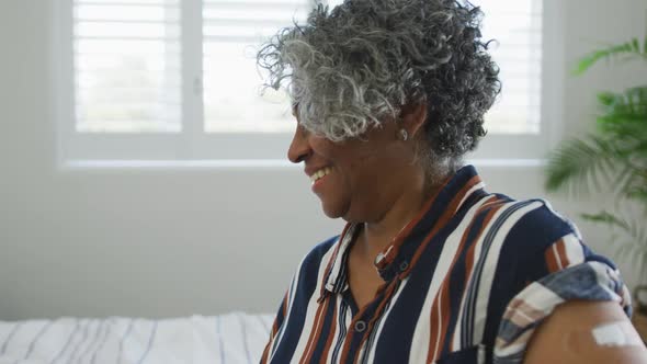 Animation of happy african american senior woman showing covid vaccinate passport