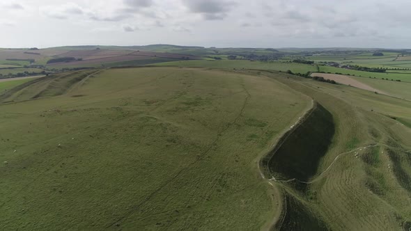 Rotating aerial around the famous  Iron-age hill fort of Maiden Castle, Near Dorchester, Dorset.