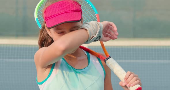 Portrait of a Girl Wearing Fuchsia Cap and Holding Tennis Racket