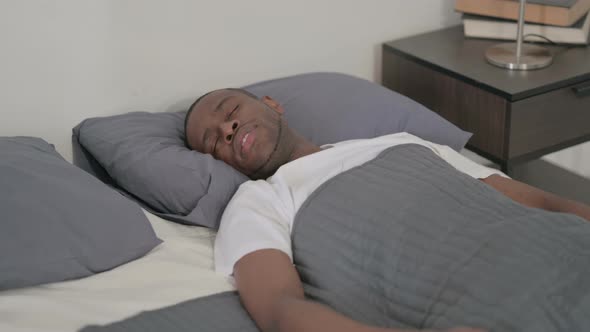 African Man Coughing While Sleeping in Bed