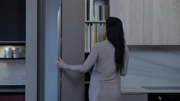 Woman Opening Cabinet with Furniture Decor and Colors Samples in Shop