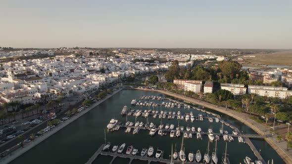 Aerial pullback Ayamonte marina reveal Coastal Spanish village, white house Landscape