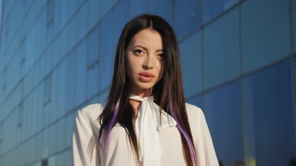 Young Lady Manager Stands Against Business Center Smiling