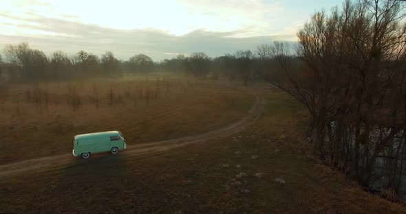 Road trip friends in hippie car. Aerial view of a retro van in fog. 