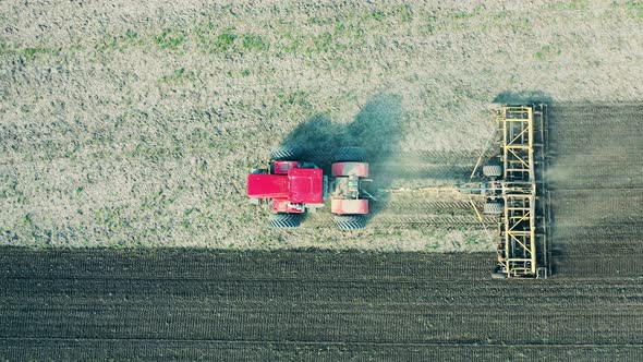 Aerial View of a Tractor, Working on a Field with Soil.