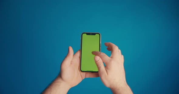 Male Hand Scrolls the Tape on the Smartphone Screen