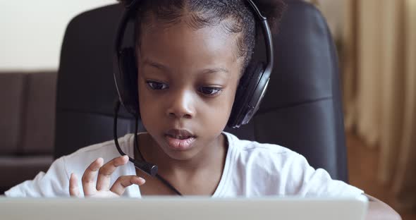 Closeup Portrait Face of African American Little Girl Wearing Headphones Talking Microphone Online