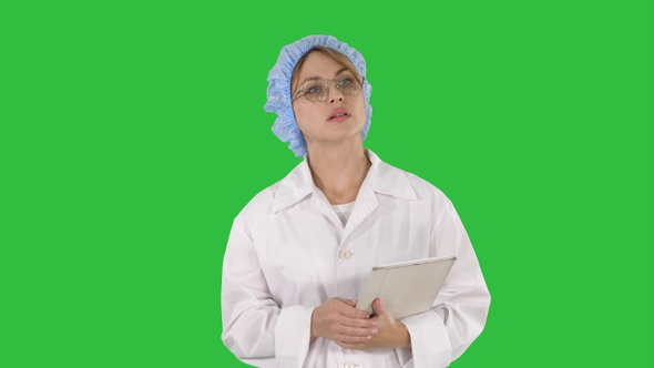 Woman doctor holding tablet and walking on a Green Screen