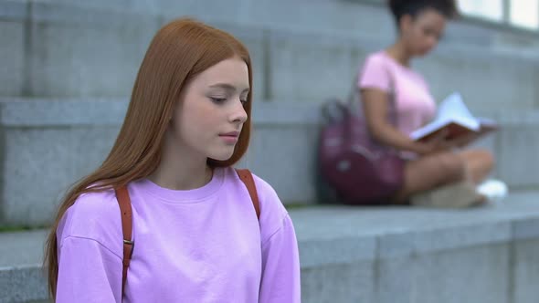 Indecisive Caucasian Female Student Sitting on Campus Stairs, Hard Choice Doubts