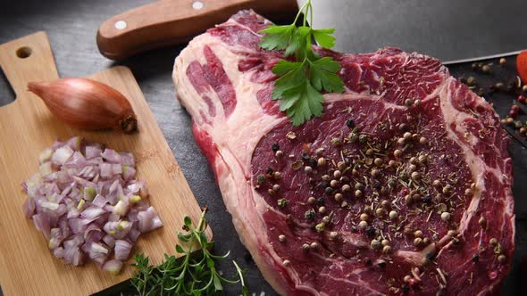 Raw T Bone steak on wooden board prepared to Grill on turntable