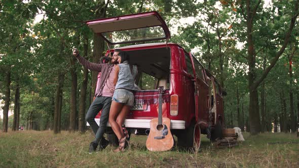 Young Happy Young Mixed Race Couple Doing Selfie Near Retro Bus in Forest and Having Some Fun Slow