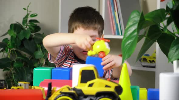 A Preschool Boy Plays a Helicopter Sitting at a Table Cubes and Cars for Children