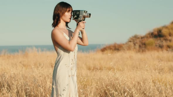 Girl in the Countryside Shoots with Vintage 8Mm Cinema Camera