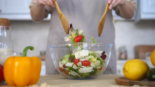 Closeup Of Woman Mixing Green Salad In A Bowl. Cooking Wholesome Food For Family Dinner