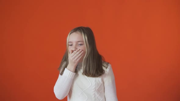 A Little Girl Coughs Against an Orange Background