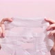 Female hands holding sheet of white mask on pink background. Stop motion animation. - VideoHive Item for Sale