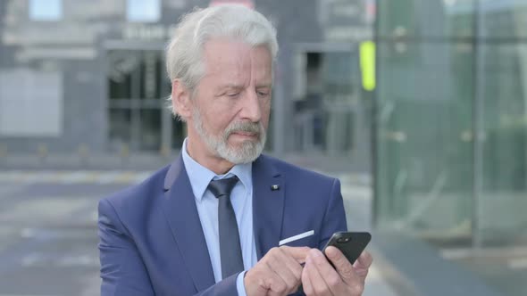 Old Businessman Using Smartphone Outdoor